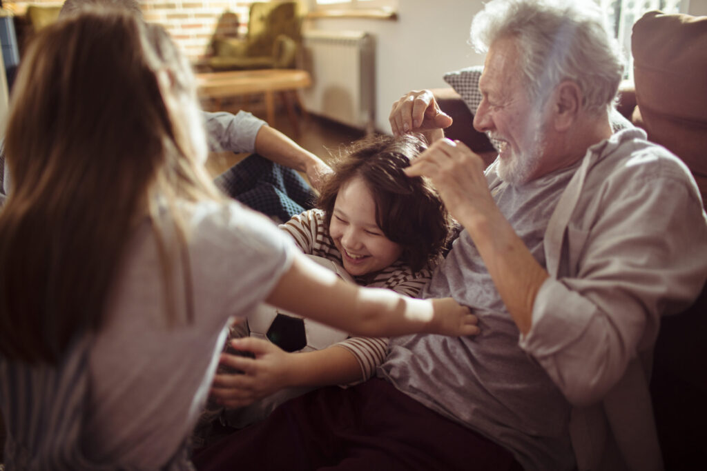 A grandfather happily playing with his young grandchild.