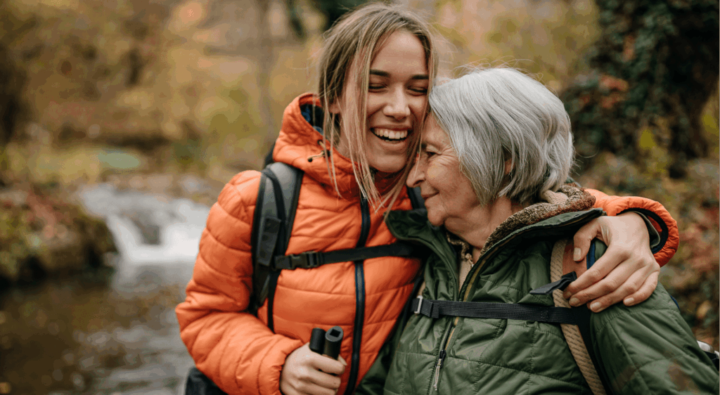 Mother and daughter walking together through a forest.