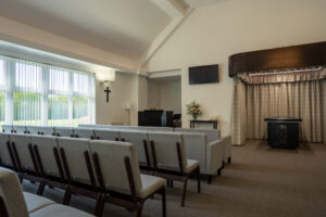 Interior of the crematorium chapel with seating facing the catafalque and curtains
